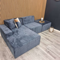 Atlanta Modula Sofa - Corner Combination by Furnish 365 Limited, featuring a modern design in soft textured blue fabric, placed against a wooden slatted wall.