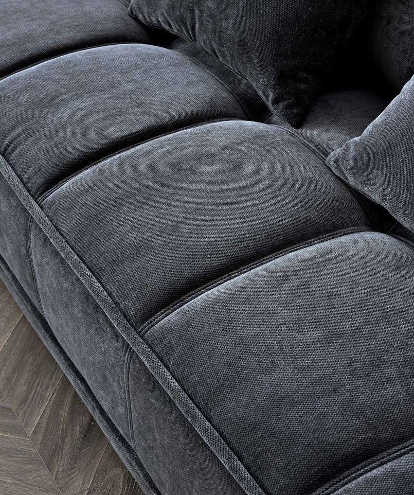 Close-up of the Aluxo Gramercy sofa in Steel Velvet, highlighting the luxurious fabric texture and tufted seat cushions for a comfortable and elegant look.