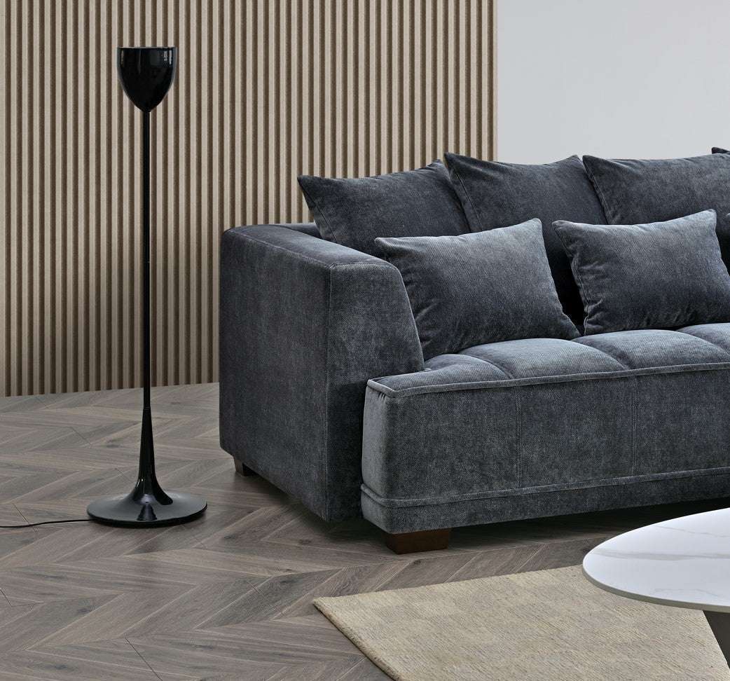 The Aluxo Gramercy Group in Steel Velvet, showcasing the sofa paired with a sleek floor lamp and textured wall backdrop.