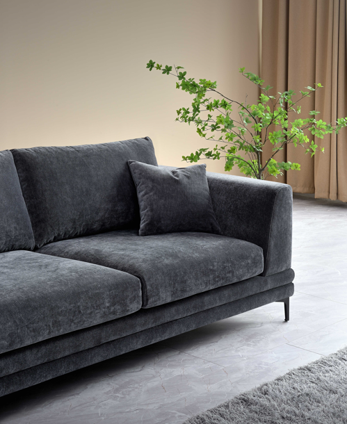 Side view of the Aluxo Lenox Sofa Range in Steel Velvet, highlighting plush cushions and minimalistic design beside natural decor.
