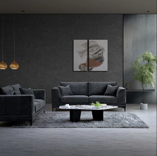 Aluxo Lenox Sofa Range in Steel Velvet, featuring a stylish living room setting with a modern aesthetic, grey walls, a round coffee table, and soft lighting.