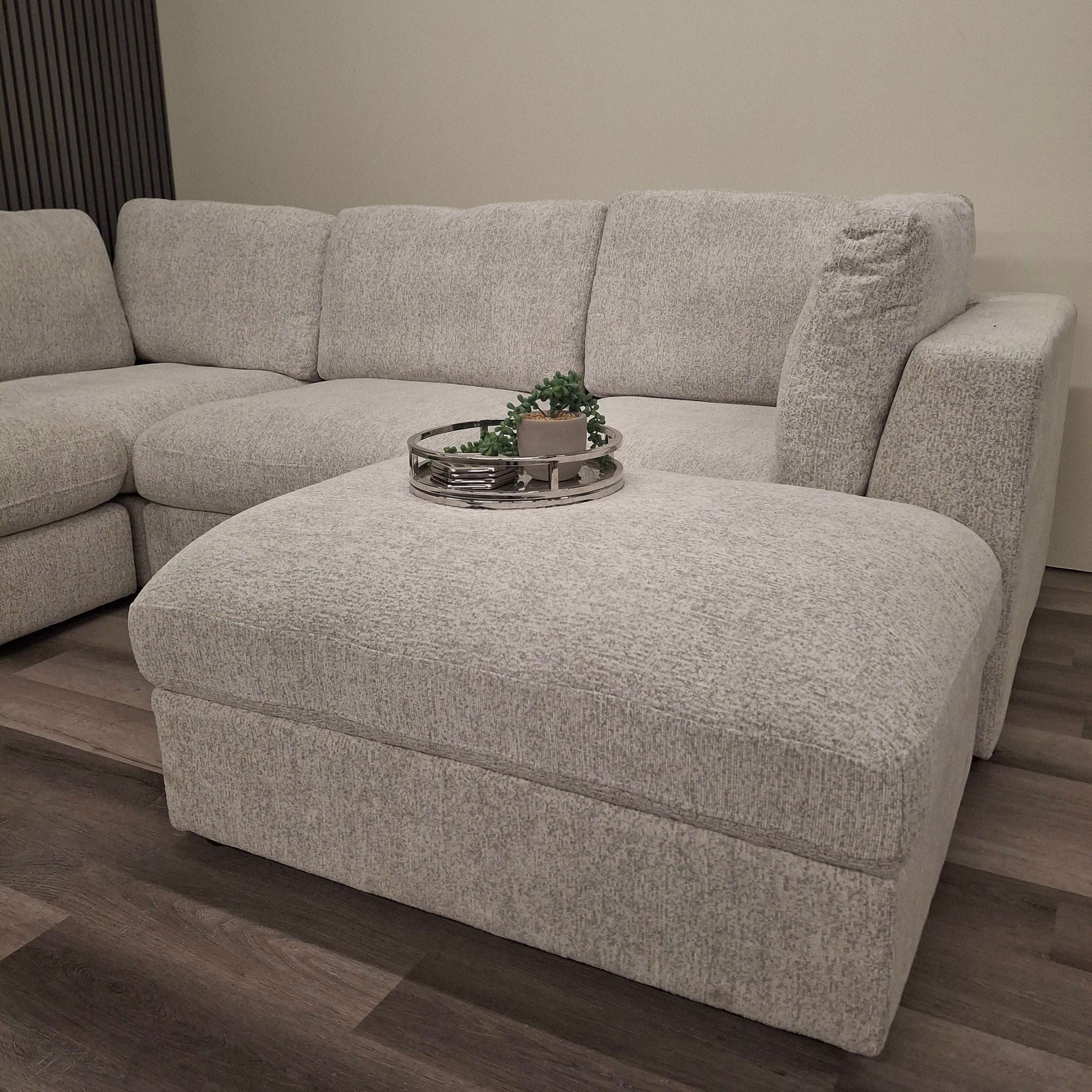 The Madison U Shape Sofa by Furnish 365 Limited, showcasing a stylish grey ottoman with décor placed on top, ideal for modern living rooms.