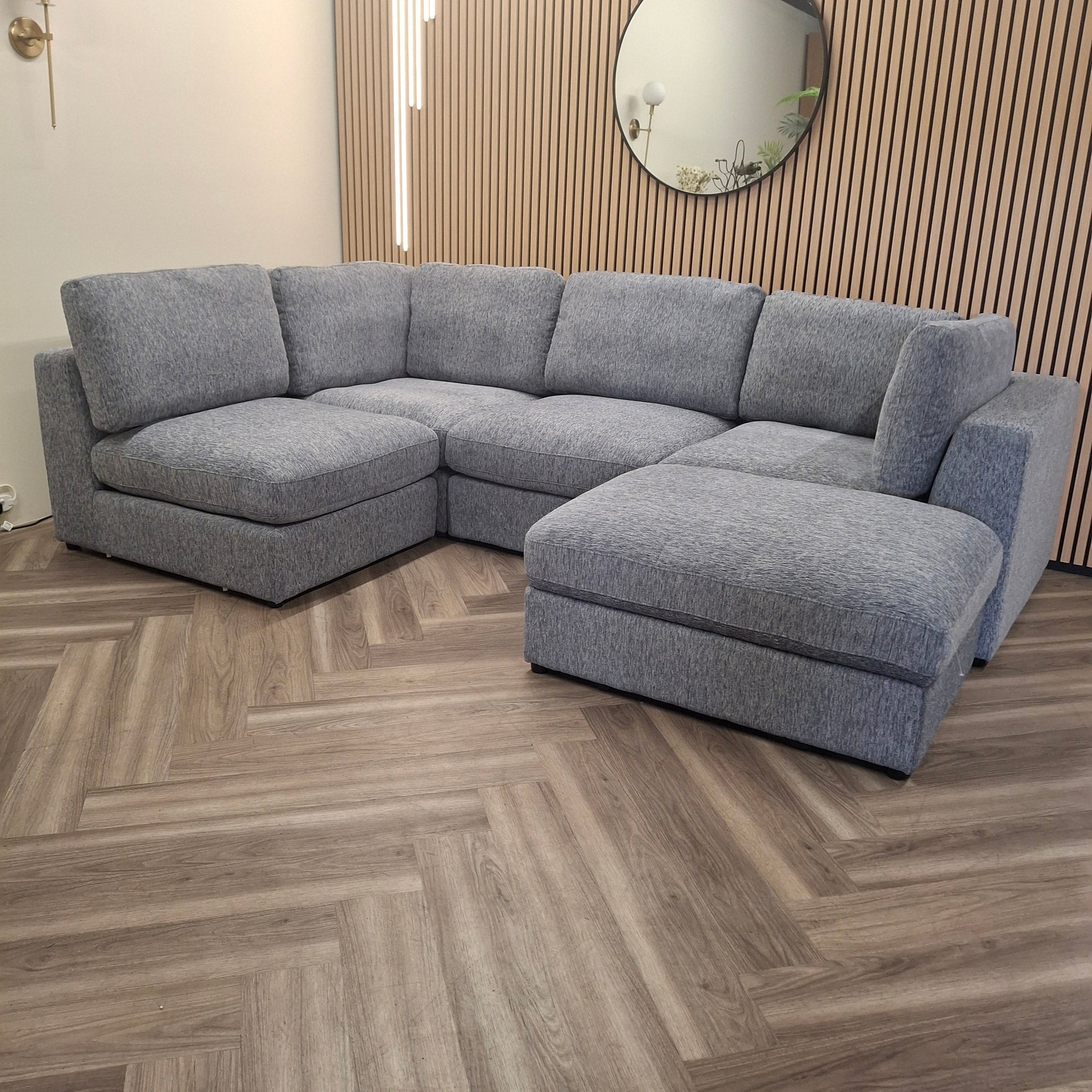 Madison U Shape Sofa by Furnish 365 Limited, featuring a spacious modular design in light grey, set against a stylish wooden backdrop.