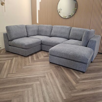 Madison U Shape Sofa by Furnish 365 Limited, featuring a spacious modular design in light grey, set against a stylish wooden backdrop.