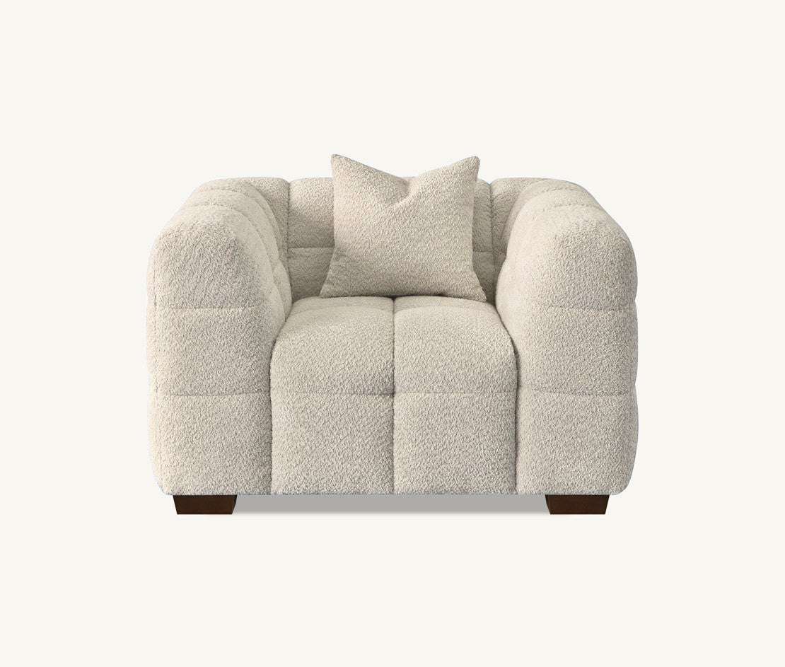 Front view of a chair from the Tribeca Sofa Range in Oatmeal Boucle Fabric by Aluxo, featuring a cozy design with a matching cushion for a contemporary living space.
