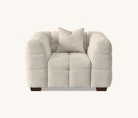 Front view of a chair from the Tribeca Sofa Range in Oatmeal Boucle Fabric by Aluxo, featuring a cozy design with a matching cushion for a contemporary living space.