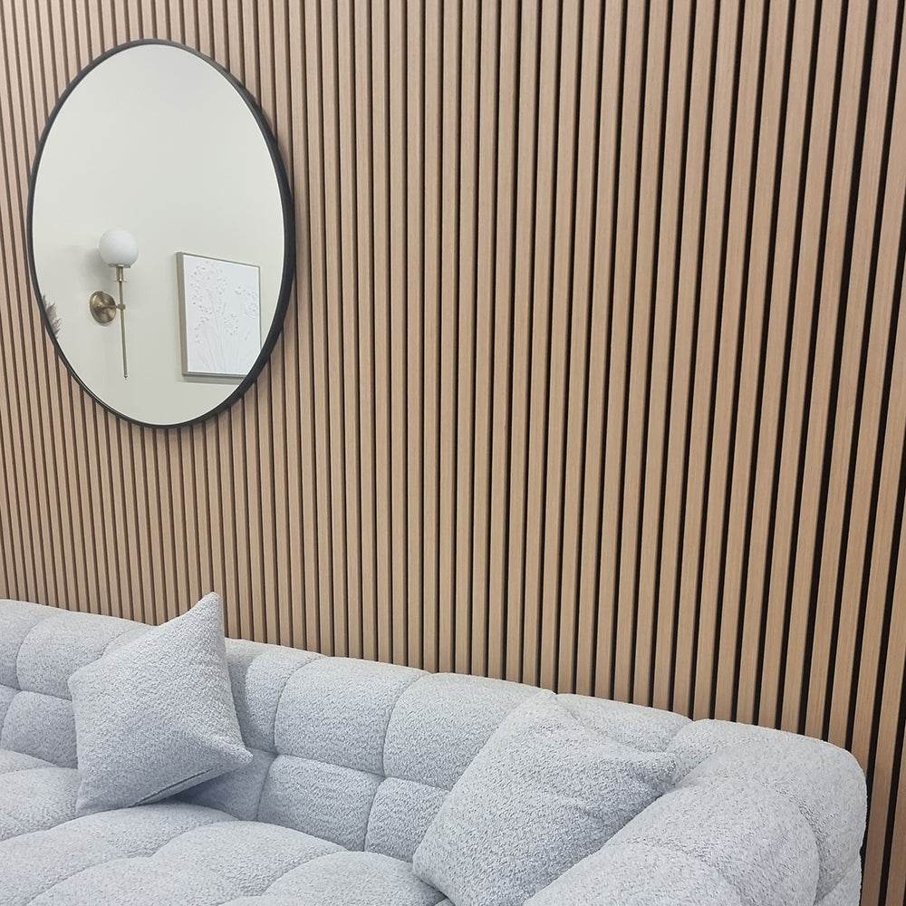 Inviting lounge area featuring Acoustic Wood Slatted Wall Panels from Furnish 365 Limited, complemented by plush grey sofa and round mirror, showcasing luxury furniture.